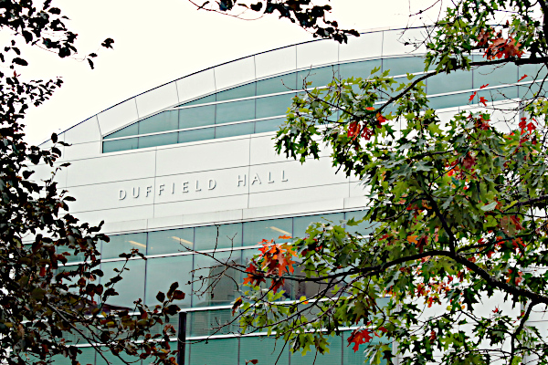 The northern facing end of Duffield Hall on a cloudy day, framed by trees